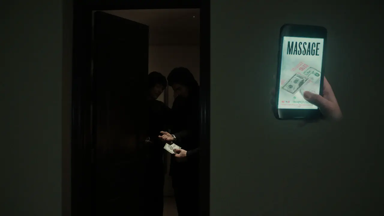 A shadowy encounter in a hidden Dubai apartment involving cash exchange for an illegal massage service.